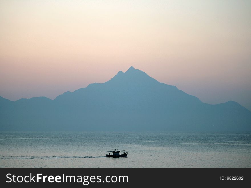 Early morning in the sea.Background the athos mountain. Early morning in the sea.Background the athos mountain.