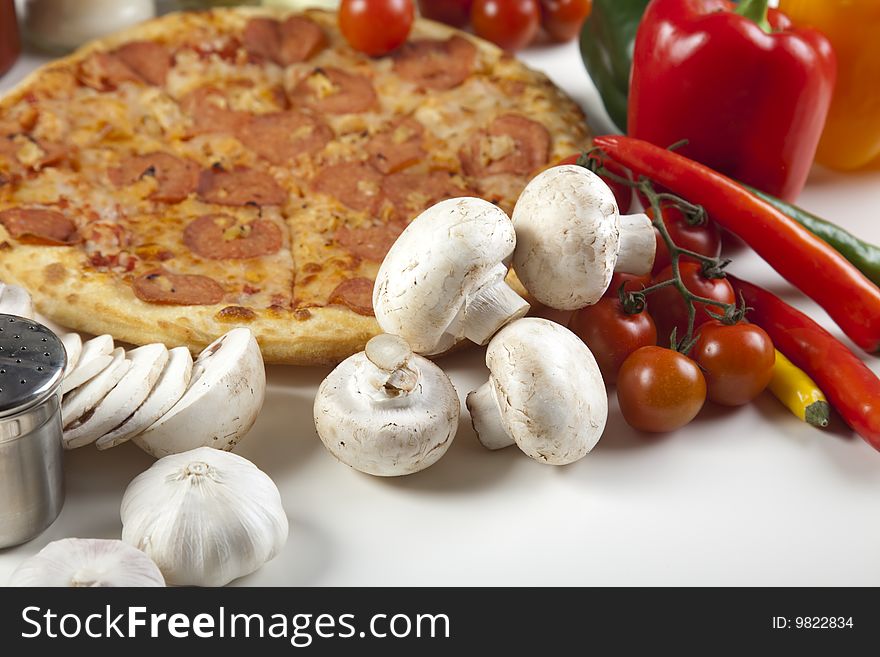 A couple of delicious pizzas, with raw tomatoes, green peppers and salami. A couple of delicious pizzas, with raw tomatoes, green peppers and salami