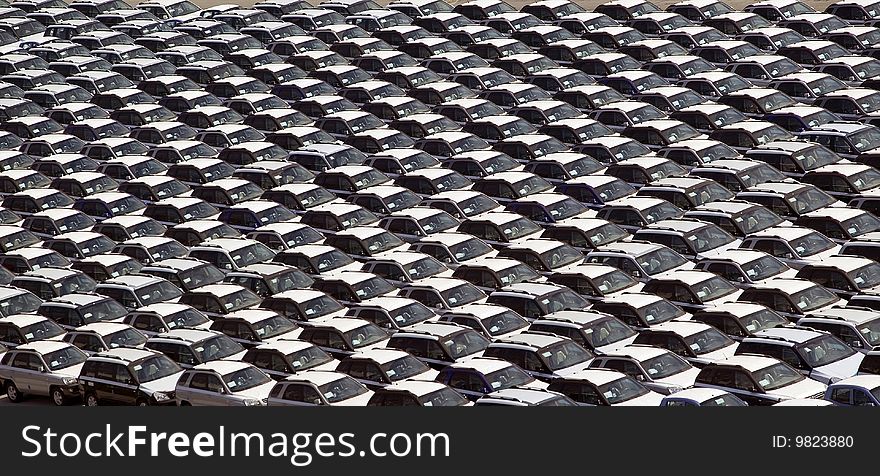 High view point of hundreds of cars parked in uniformed lines. High view point of hundreds of cars parked in uniformed lines