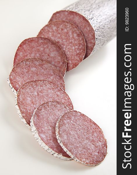 Macro picture of slice of salami isolated on white background