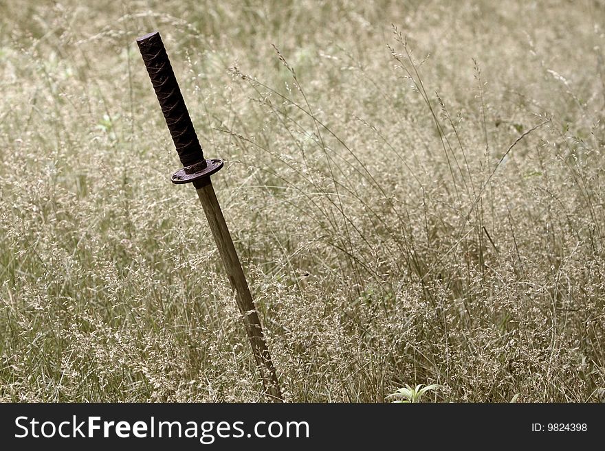 Samurai sword stuck in the ground in a field. Samurai sword stuck in the ground in a field