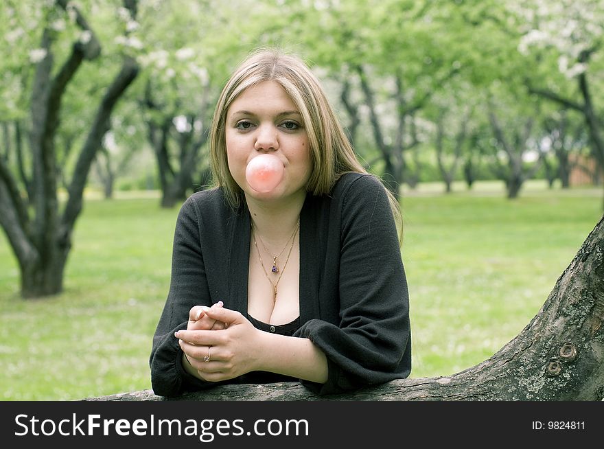 Beauty blond girl blowing bubble gum