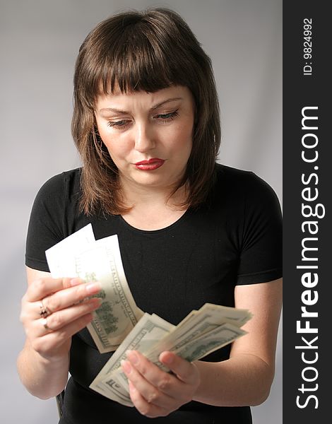 Sullen young woman counts money in her hands. Sullen young woman counts money in her hands.