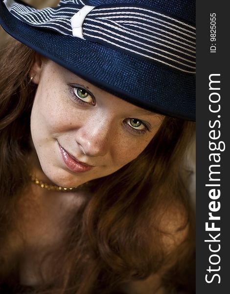 Head shot of a young, red haired lady wearing a blue hat. Head shot of a young, red haired lady wearing a blue hat.