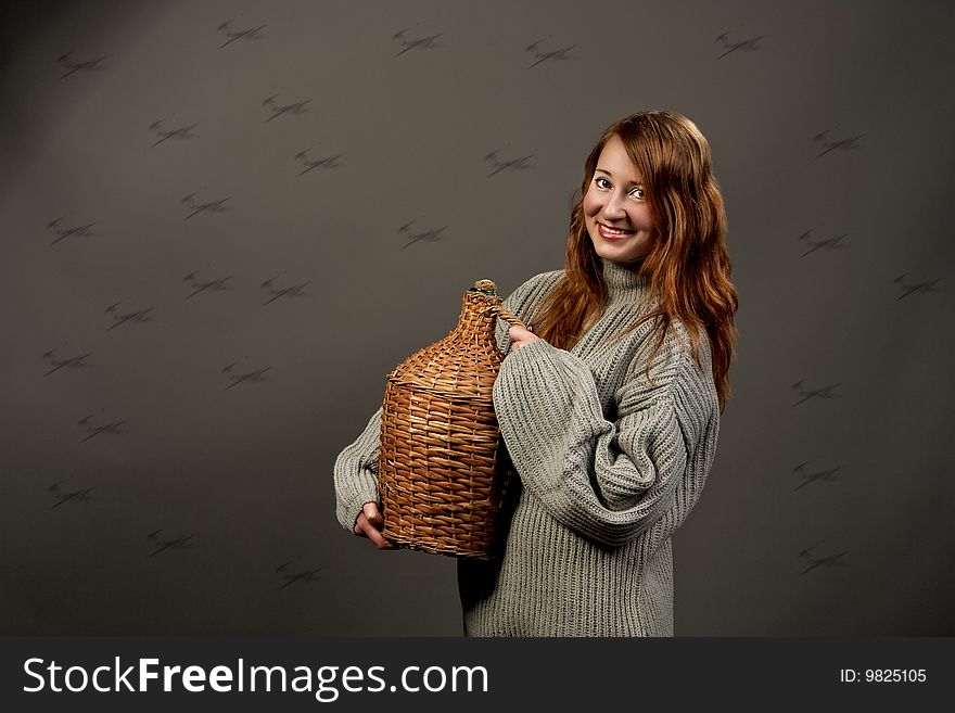 Laughing red haired woman in grey sweater with jar isolated