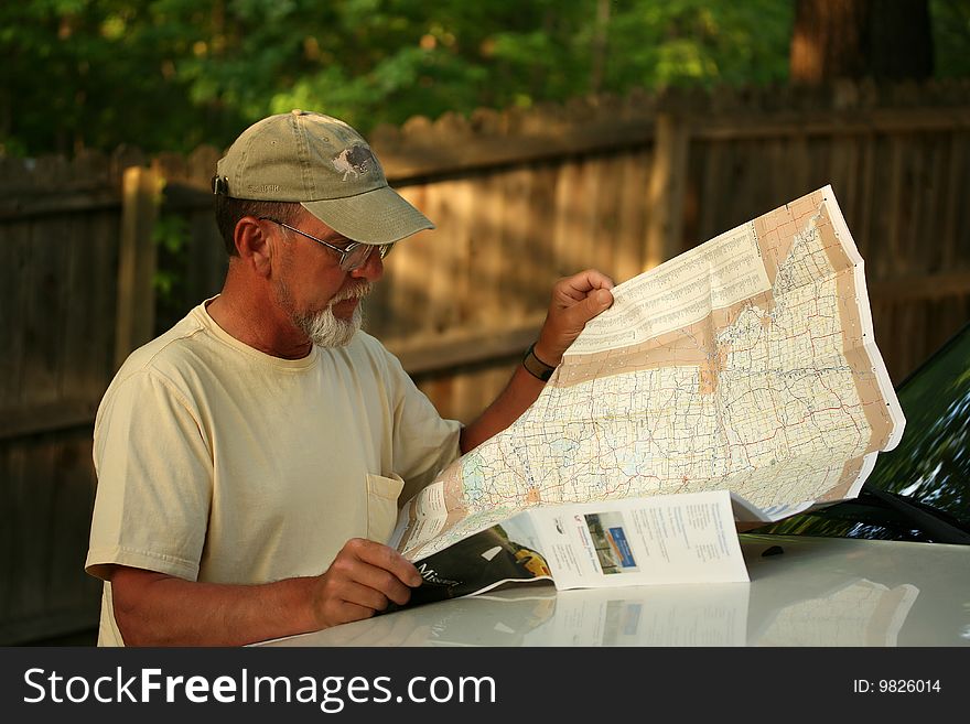 Mature adult male reading map while on vacation. Mature adult male reading map while on vacation