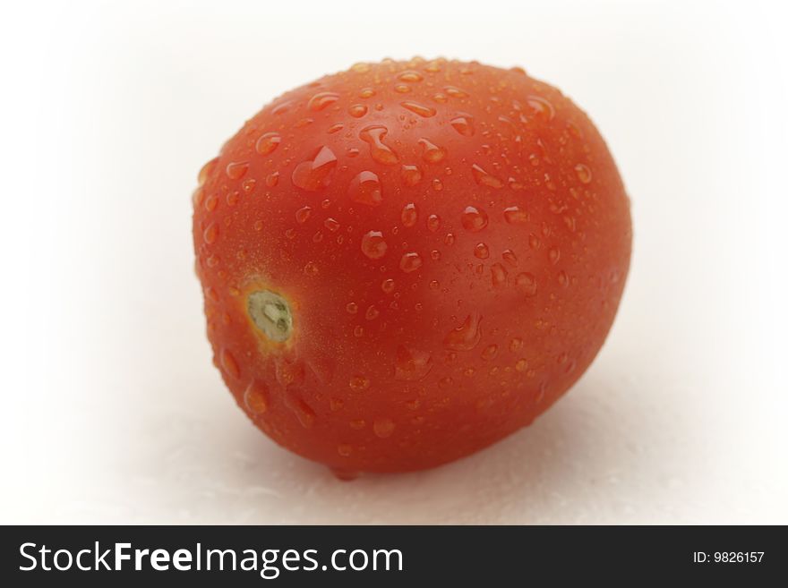 Three red tomatoes with water drops on white background