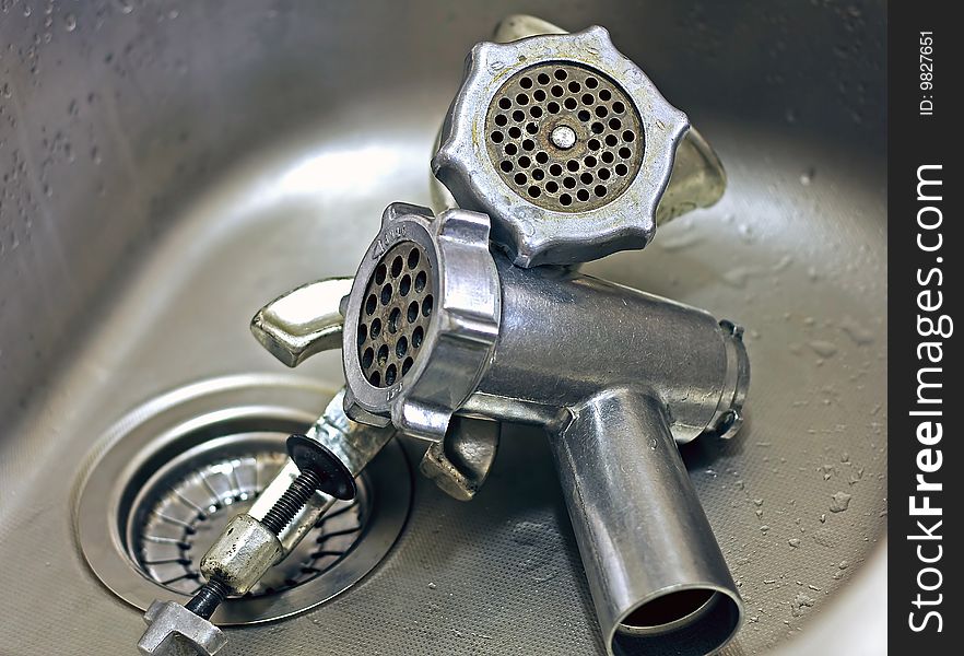 Pair of clean meat grinders in a stainless steel sink. Pair of clean meat grinders in a stainless steel sink