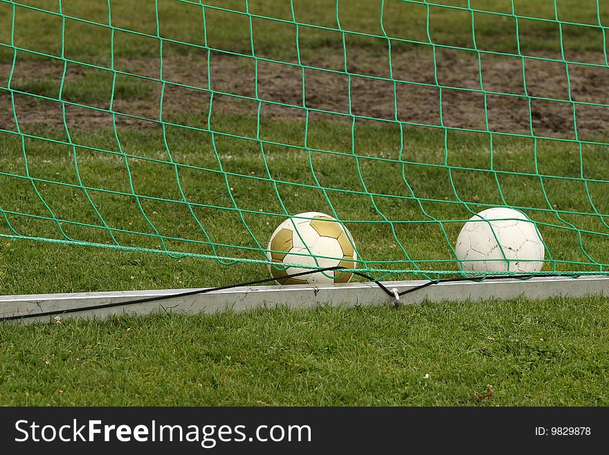 Two soccer balls in a goal. Two soccer balls in a goal