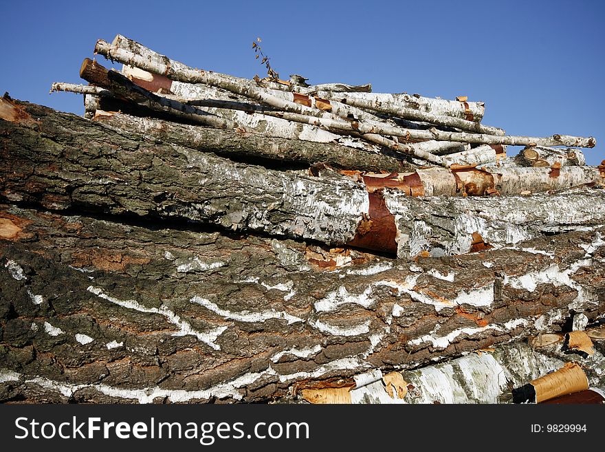 Stack of chopped wood on a wood yard in Upper Silesia, Poland. Pile of birch trees. Stack of chopped wood on a wood yard in Upper Silesia, Poland. Pile of birch trees.