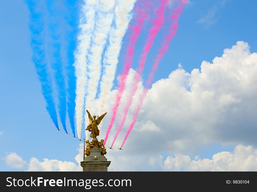 Planes with a multi-coloured smoke fly over the Buckingham palace to time of parade of military-air forces