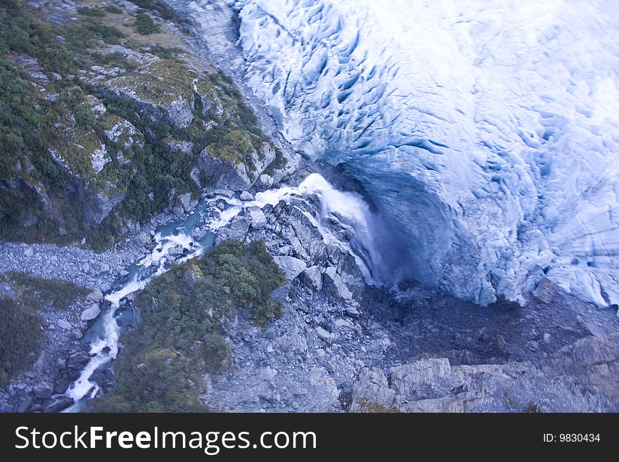 Waterfall flowing under a Glacier