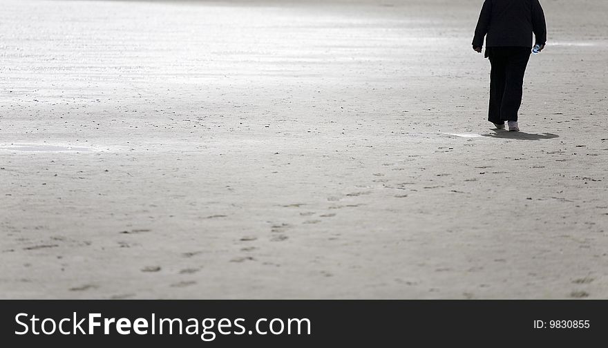 Woman walking on sand beach in early spring