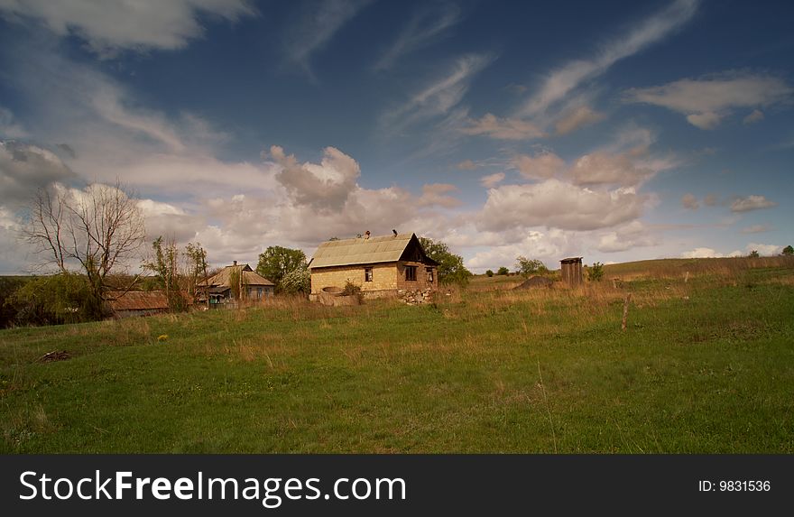 The house in the field in sunset beams. The house in the field in sunset beams