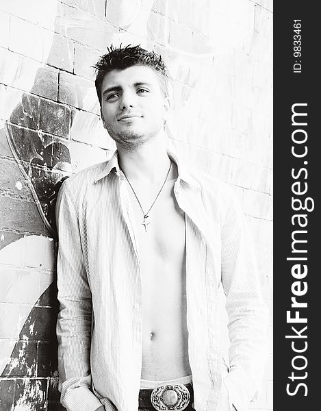 Portrait of handsome young man near the wall in black and white. Portrait of handsome young man near the wall in black and white