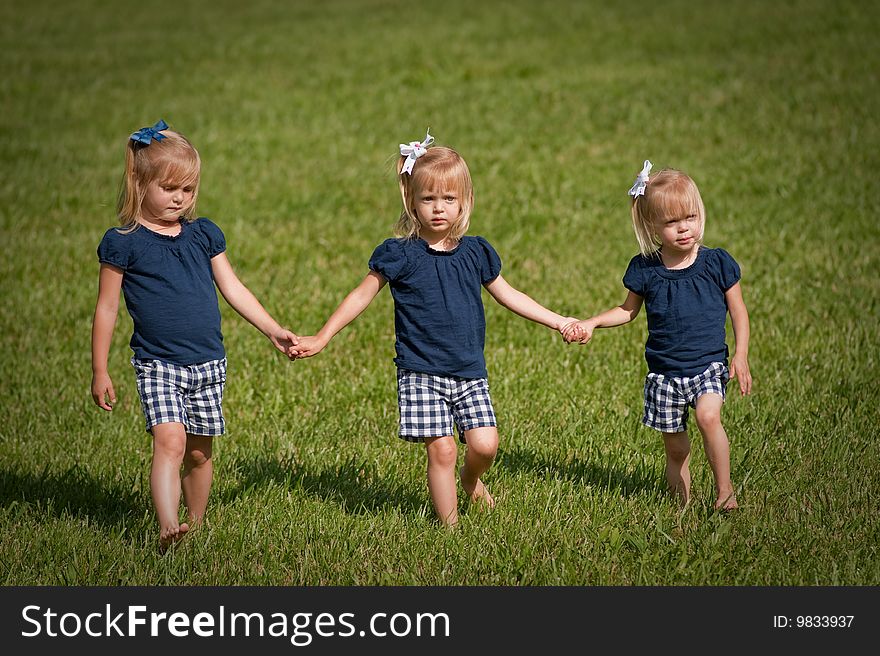 Three sisters walking in a field