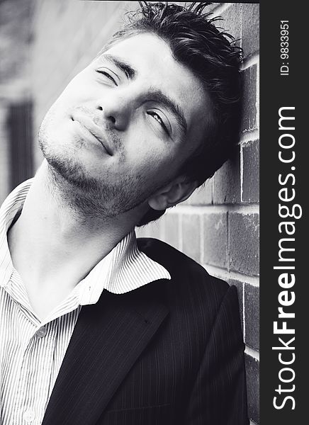 Portrait of young handsome man near the wall - black and white. Portrait of young handsome man near the wall - black and white