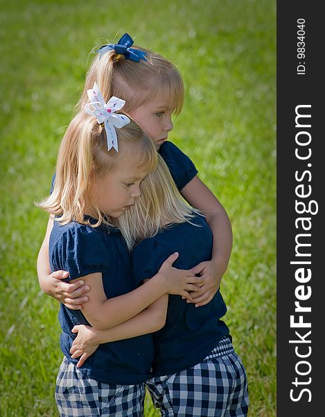 Three sisters dressed alike and hugging each other with sad expressions on faces. Three sisters dressed alike and hugging each other with sad expressions on faces