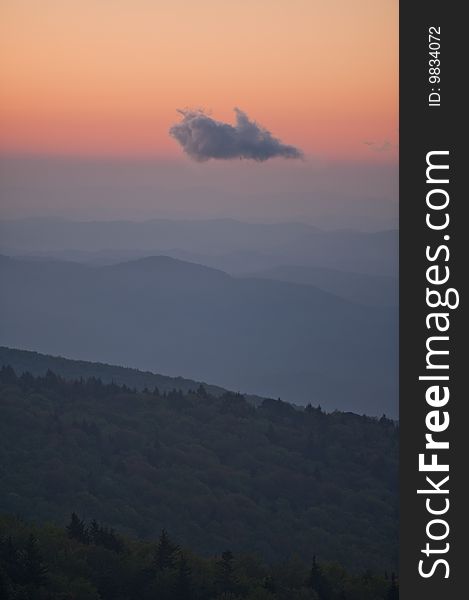 Sunrise blues and pinks with mountain ridges and one cloud hovering in sky at Grandfather Mountain in North Carolina, USA. Sunrise blues and pinks with mountain ridges and one cloud hovering in sky at Grandfather Mountain in North Carolina, USA