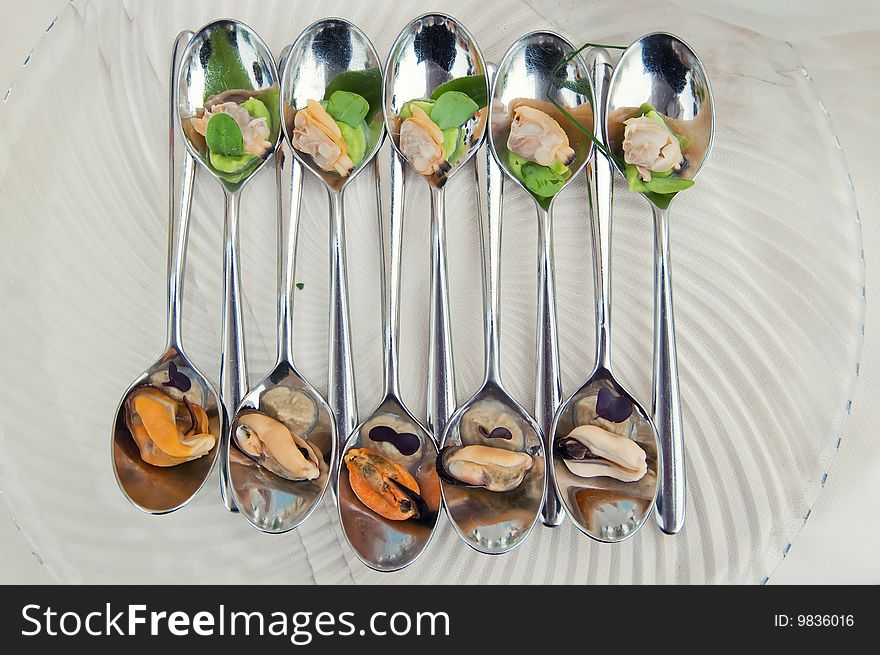 Mussel and arranged in a very stilish composition on a spoon. Mussel and arranged in a very stilish composition on a spoon