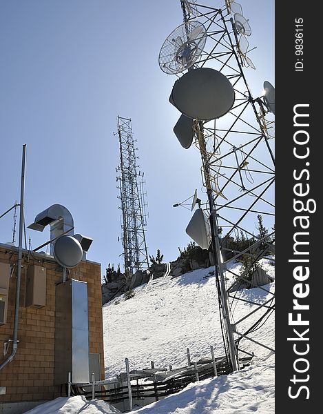 Remote Telecommunication Towers on Top of Mountain Peak in Spring. Remote Telecommunication Towers on Top of Mountain Peak in Spring
