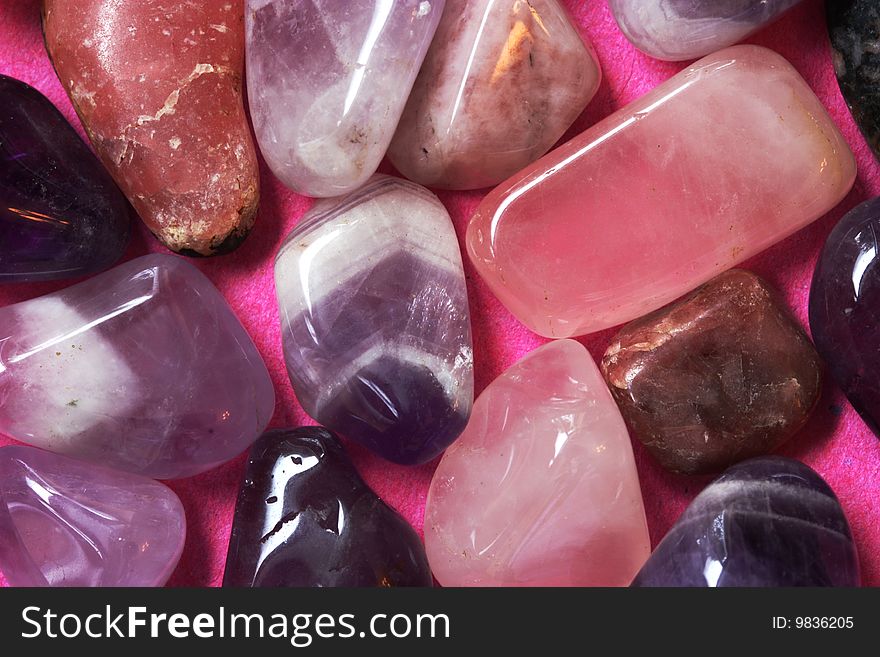 A macro photo of pink and violet polished stones