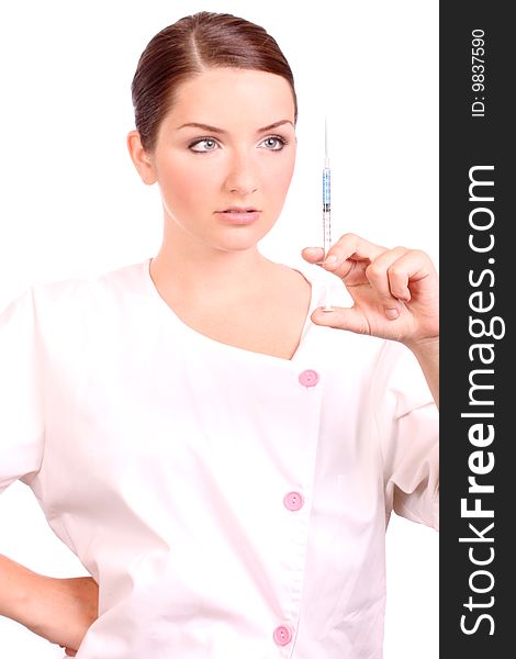 A beautiful young nurse holding a syringe and looking at it on a white background. A beautiful young nurse holding a syringe and looking at it on a white background.