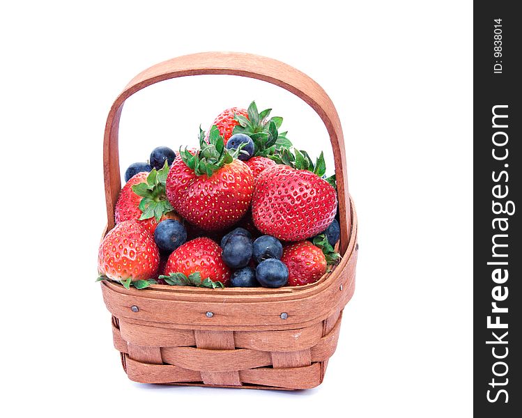 A small basket of fresh strawberries and blue berries. A small basket of fresh strawberries and blue berries.