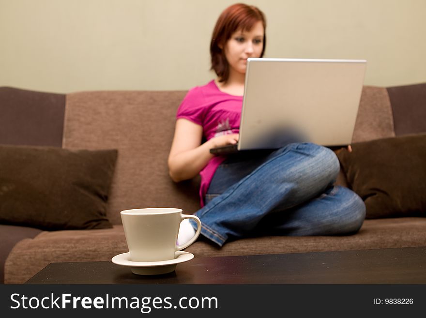 Woman with laptop on sofa