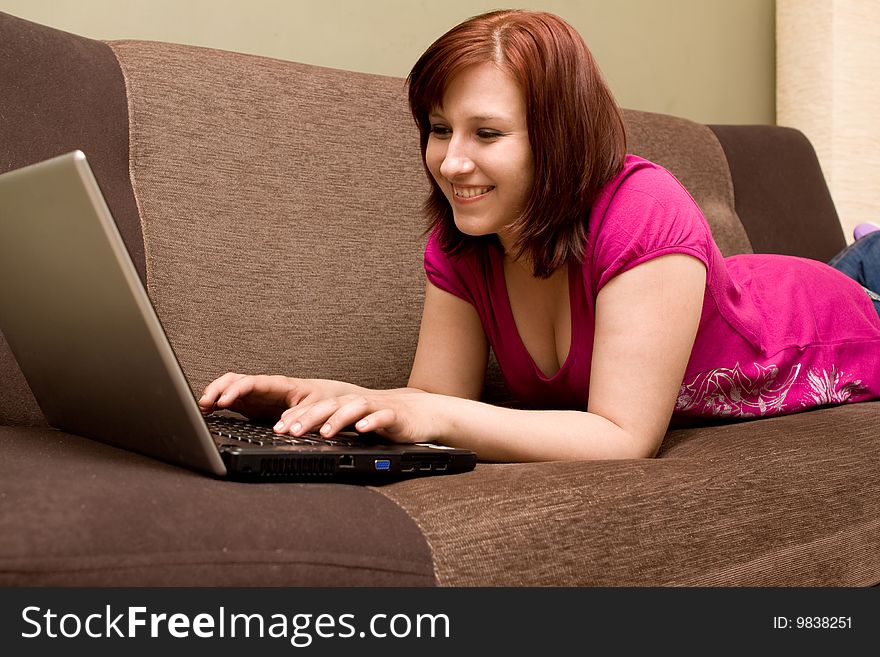 Woman with laptop on sofa