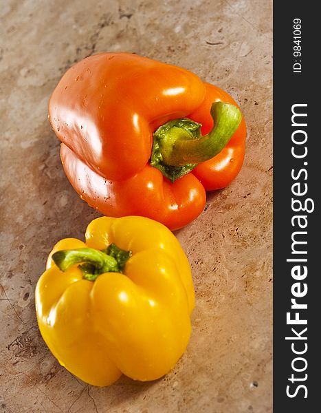 Yellow and orange paprika on a stone counter