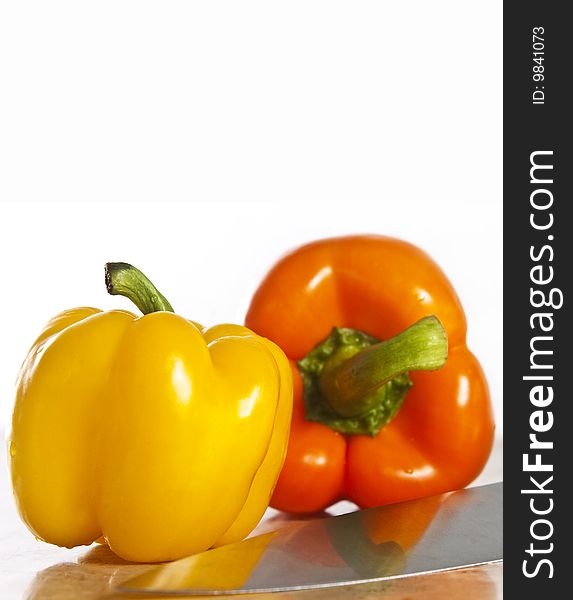 Yellow and orange paprika on a stone counter