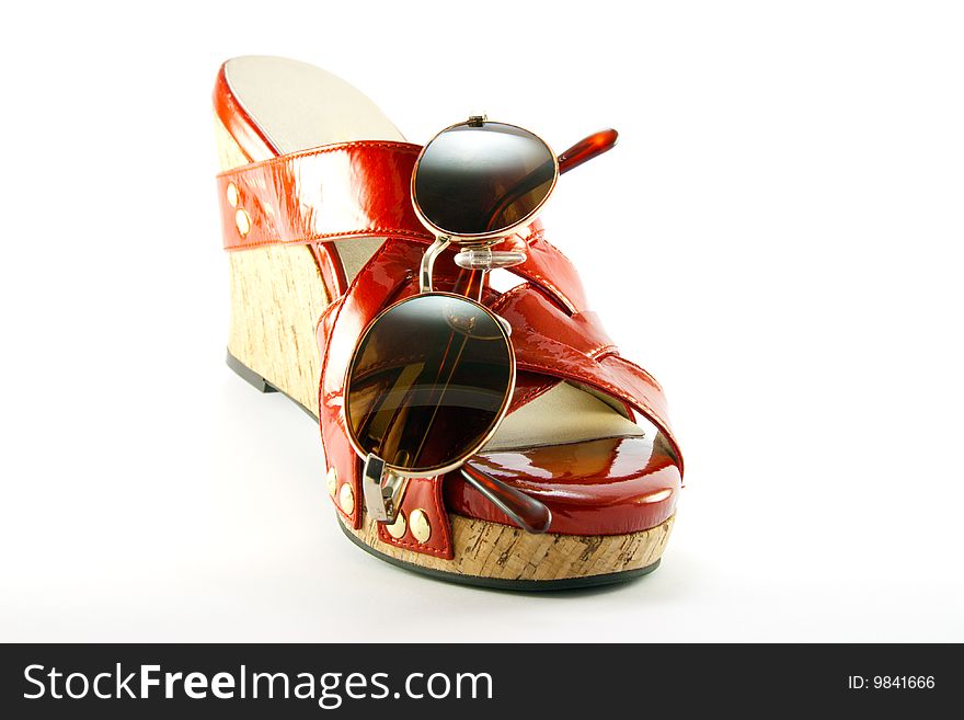 Single red shoe and brown sunglasses with clipping path on a white background. Single red shoe and brown sunglasses with clipping path on a white background