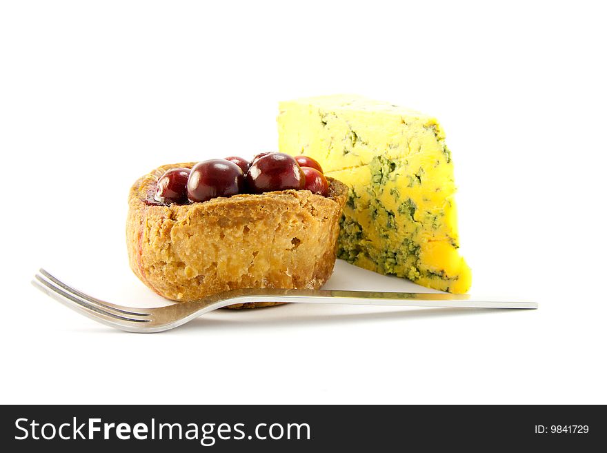 Pork pie and slice of blue cheese with fork and clipping path on a white background. Pork pie and slice of blue cheese with fork and clipping path on a white background