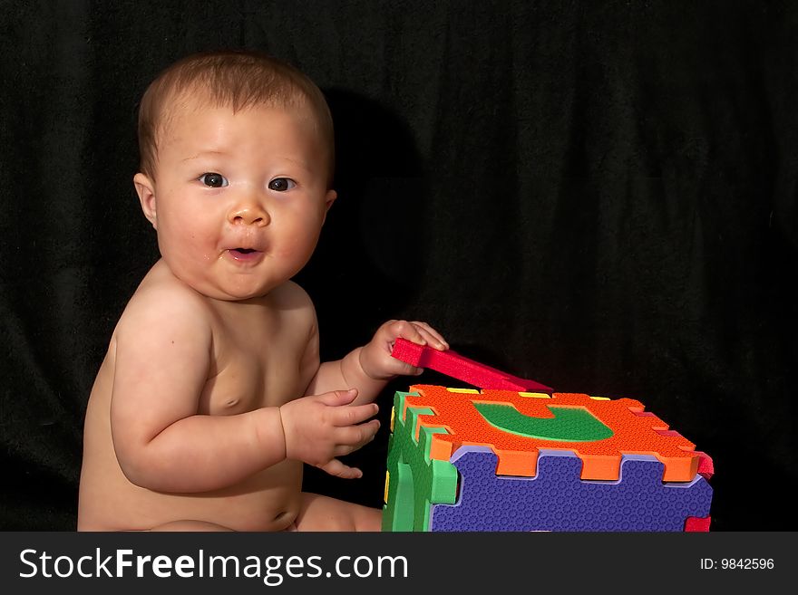 Young baby shows surprise and excitement while playing with block toys. Young baby shows surprise and excitement while playing with block toys