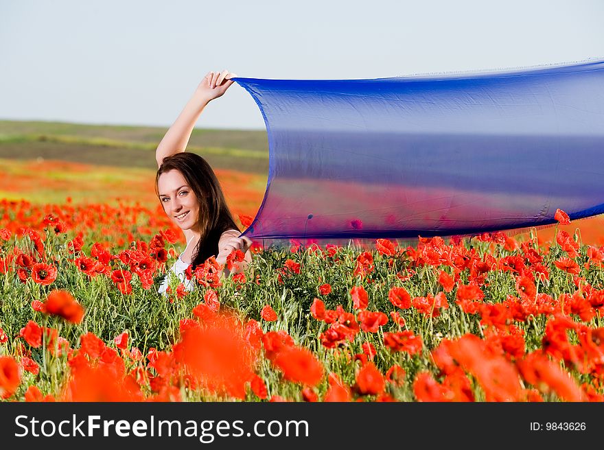 Attractive girl with blue scarf in the poppy field. Attractive girl with blue scarf in the poppy field