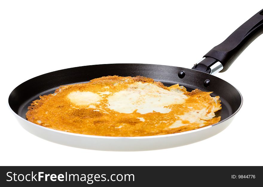 Pancake cooking in a pan isolated on white
