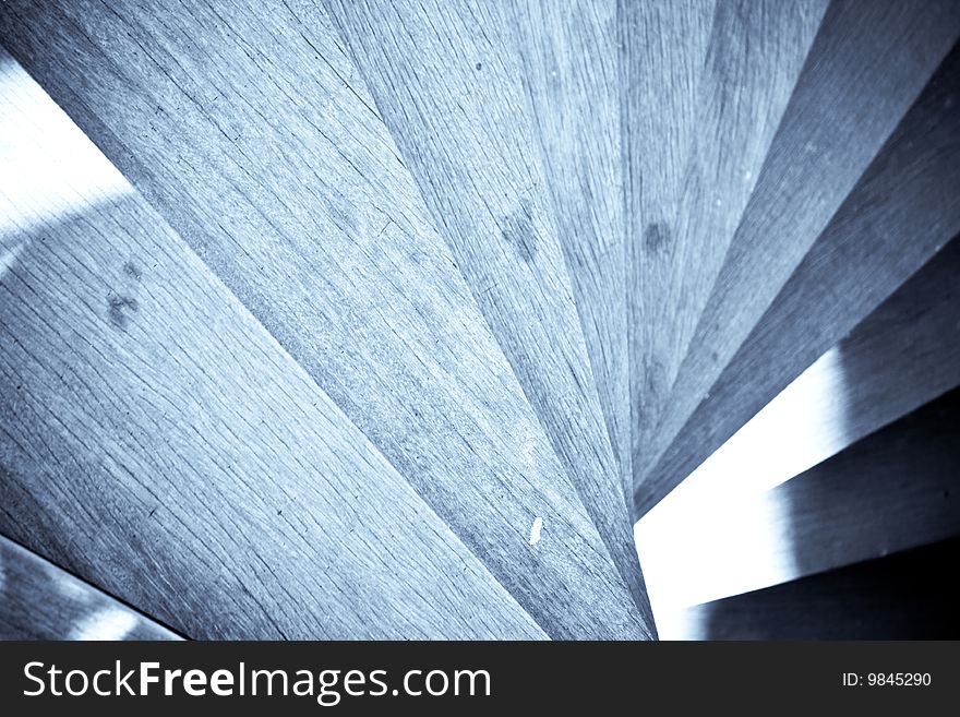 Wooden staircase spiralling downwards in selenium tone