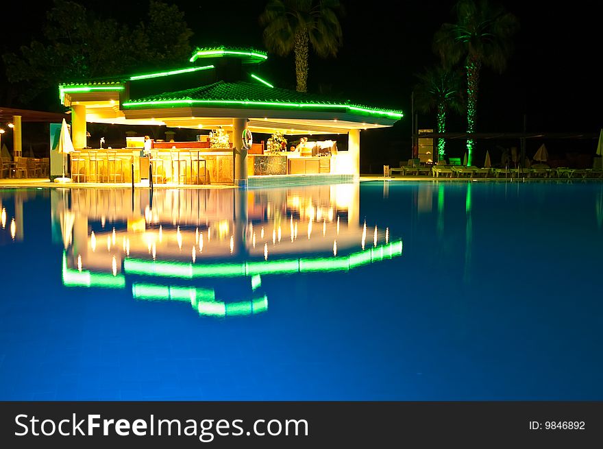 Night time photo of a swimming pool at a tropical resort