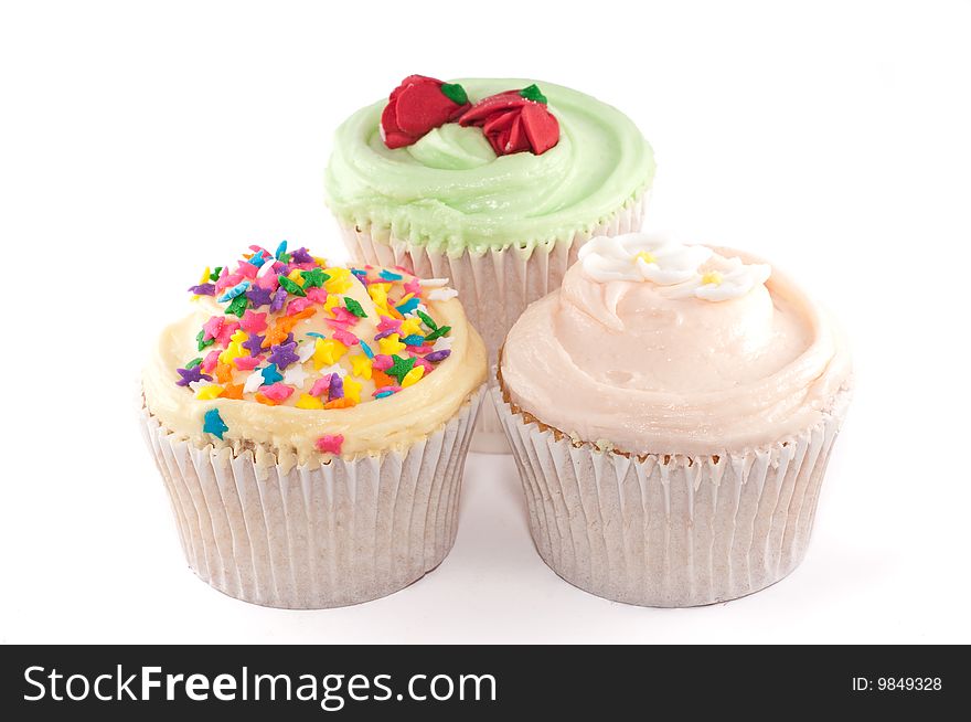 A small group of cupcakes with lovely decorations, isolated on a white background