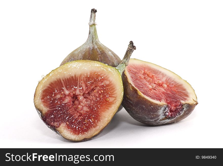 A two figs isolated on a white background, one is sliced in half.