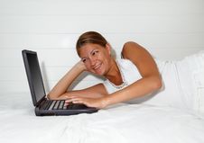 Young Smiling Businesswoman Using Laptop In Bed Stock Photo