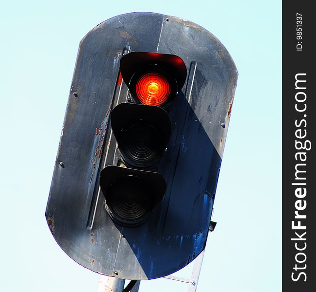 Old railway traffic light with  included red signal on  background of  sky