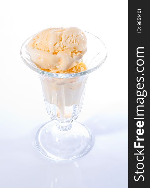 Vanilla ice cream in glass parfait cup. Hi-key photo with white background and only the contours of the cup visible. Vanilla ice cream in glass parfait cup. Hi-key photo with white background and only the contours of the cup visible.