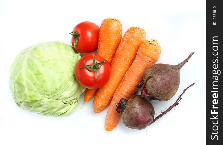 Three big  fresh carrots, the heads of cabbage, two  tomatoes  and two beets on the  table. Three big  fresh carrots, the heads of cabbage, two  tomatoes  and two beets on the  table