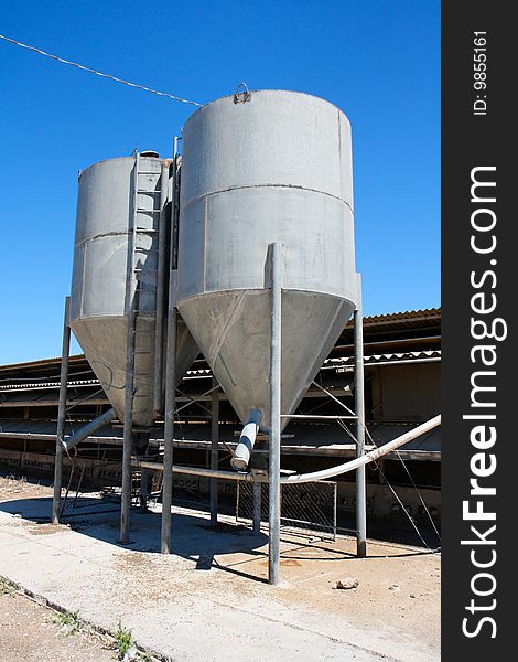 Two small gray tower silos on farm. Two small gray tower silos on farm