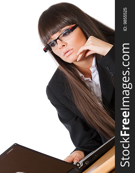 Beautiful brunette business girl working on her laptop computer shot diagonally, isolated on white