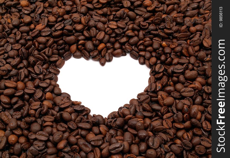 A crowd of coffee beans shows a heart-shape (white background). A crowd of coffee beans shows a heart-shape (white background)