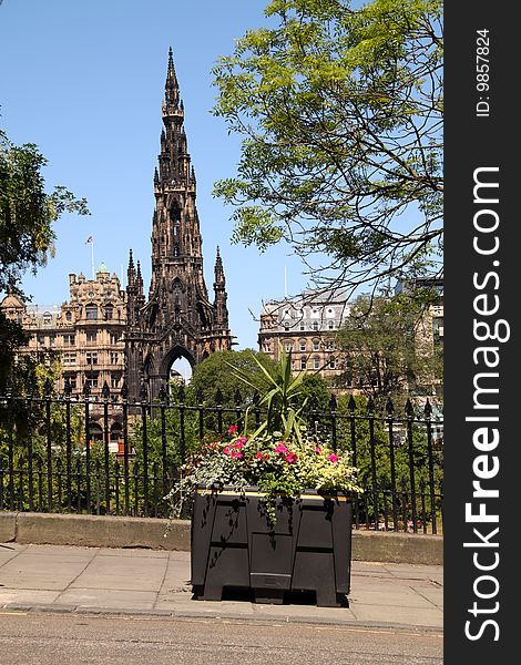 The Scott Monument on Edinburgh's Princes Street with a colourful floral tub in the foreground. The Scott Monument on Edinburgh's Princes Street with a colourful floral tub in the foreground.