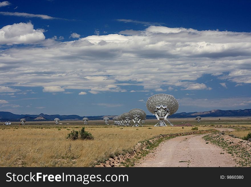 Very large array of radio telescopes against clouded blue sky. Very large array of radio telescopes against clouded blue sky.